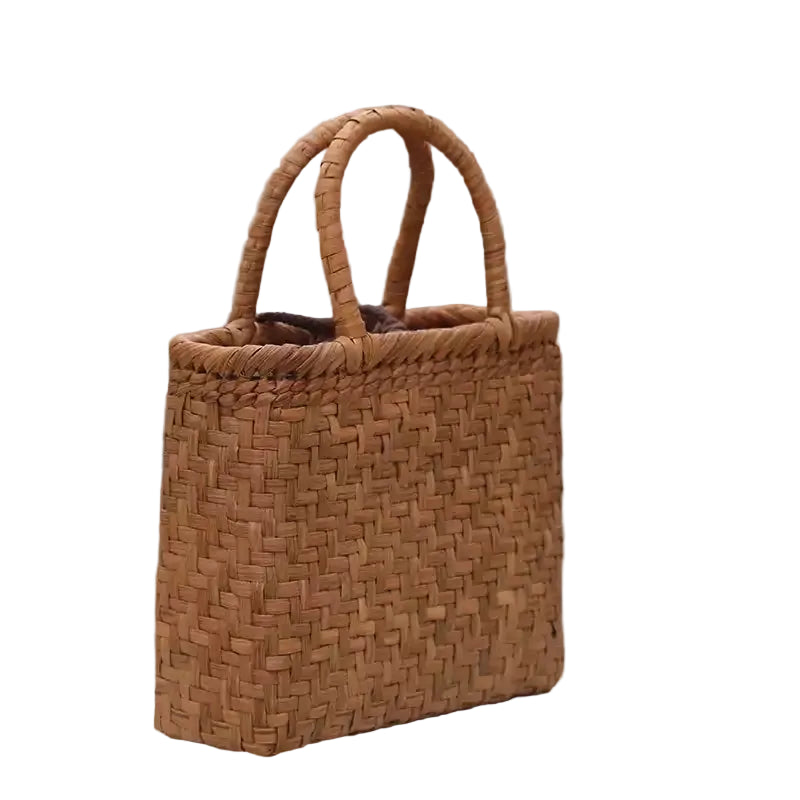 Woven brown handbag on a surface with a blurred background