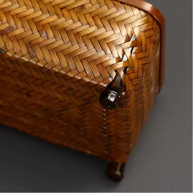 Close-up of a woven basket with a metallic clasp on a dark background